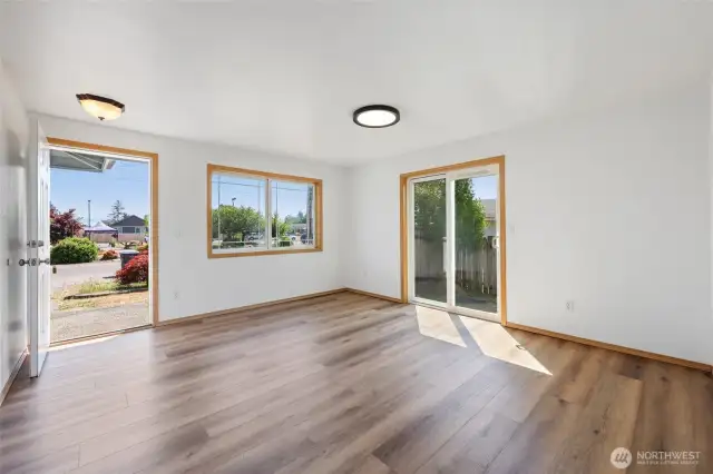 The entrance leads directly into the living area, featuring a sliding glass door that opens to a private side yard with a patio