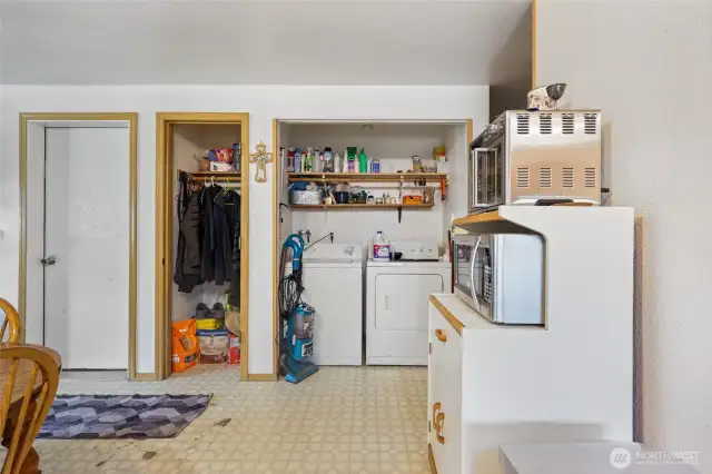 Another angle of the kitchen, showcasing the laundry area. In this unit, the doors to the laundry space have been removed for an open layout.