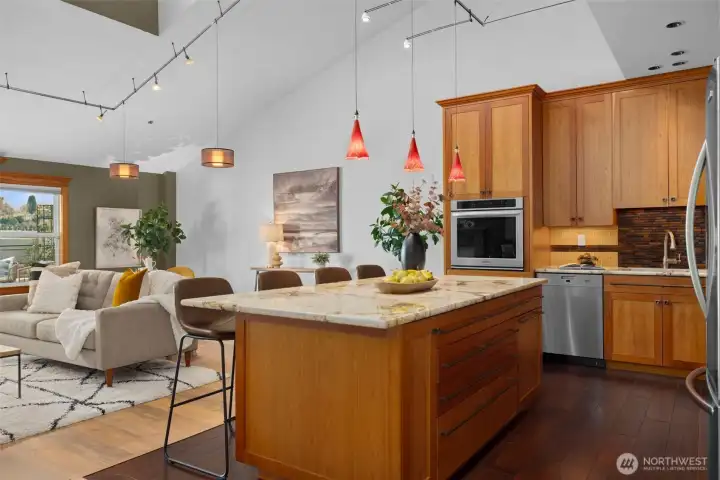 Chef-inspired kitchen with stone countertops, designer pendant lighting, and ample prep and gathering space.