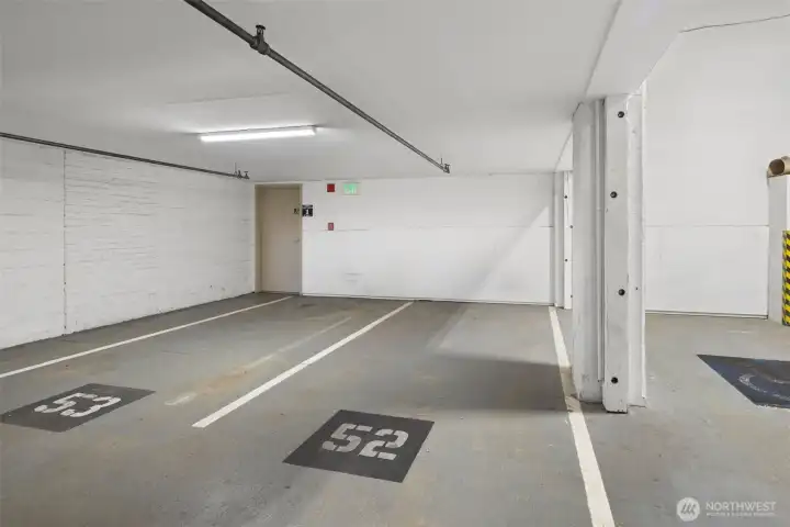 Secure parking garage with clearly marked stalls, offering convenience and peace of mind in the city. Stalls #52 and #69 are assigned to the unit.