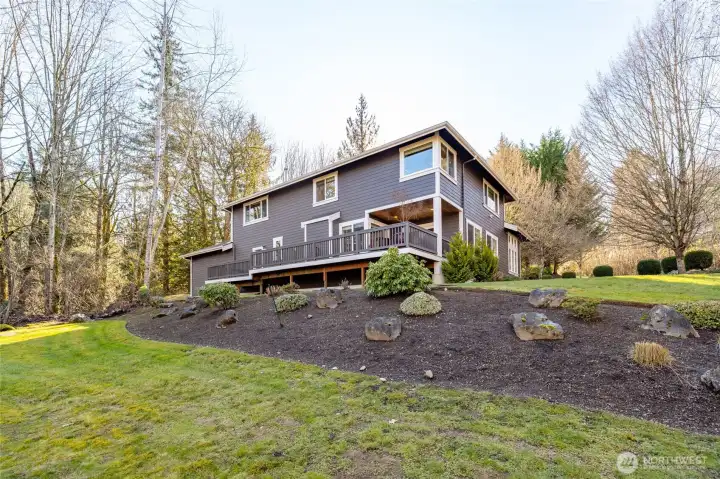 Mature landscaping and sweeping lawns surround the home, offering a serene, park-like backdrop