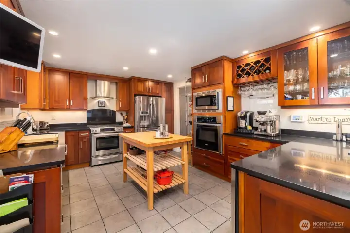 Totally remodeled and upgraded kitchen with soft - pull cherry cabinets, quartz countertops, two ovens, wine/beverage fridge. central vac system and tile flooring.  All kitchen appliances stay.