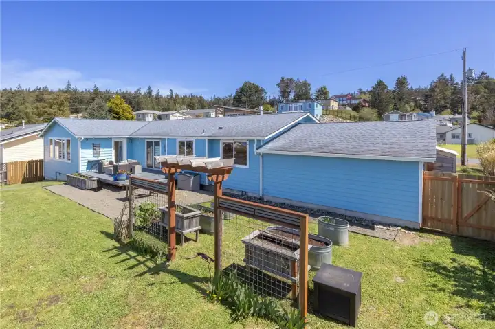 Fully fenced backyard with garden area and large deck