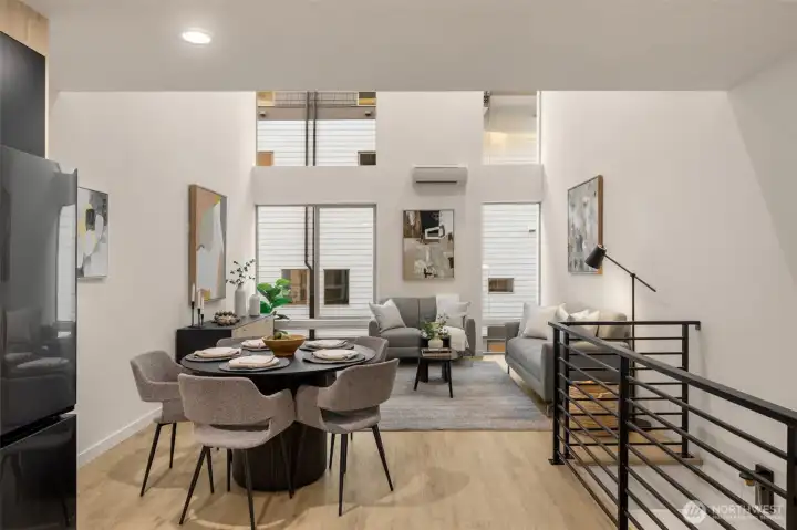 View of the dining area featuring contemporary lighting and sleek iron railings.