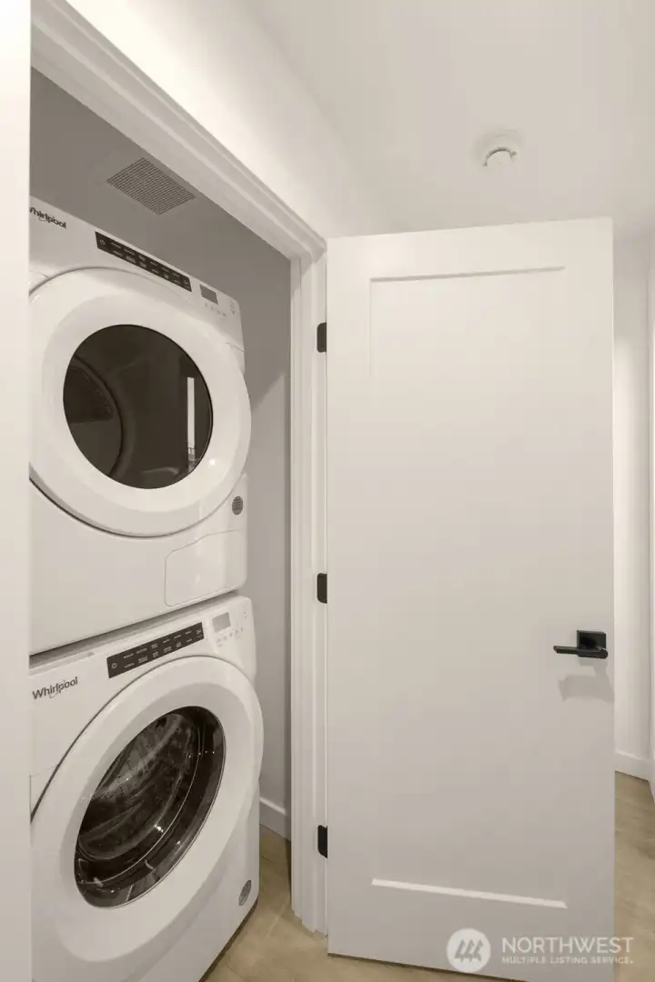 Dedicated laundry area with high-efficiency machines and functional storage.