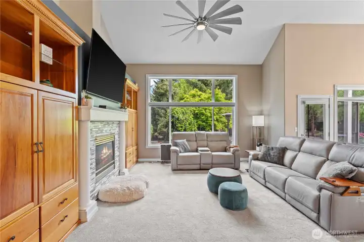 Casual great room features large windows, 2 story ceilings and a cozy fireplace with extensive built ins