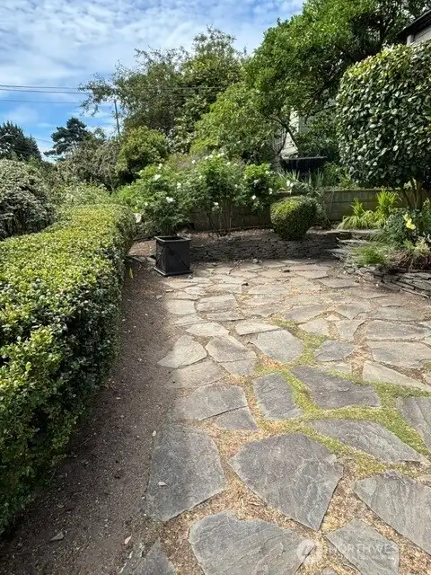 The front flagstone terrace is a welcoming place for a cafe table to enjoy the sun. The front flagstone terrace is a welcoming place for a cafe table to enjoy the sun.