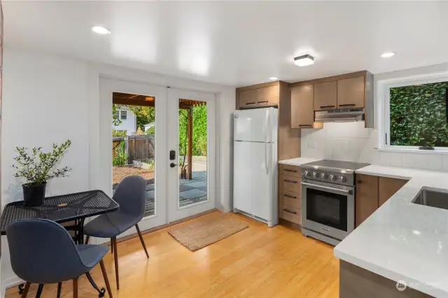 Brand new lower level kitchen with quartz counters, new cabinetry, stainless steel appliances and door to the backyard.