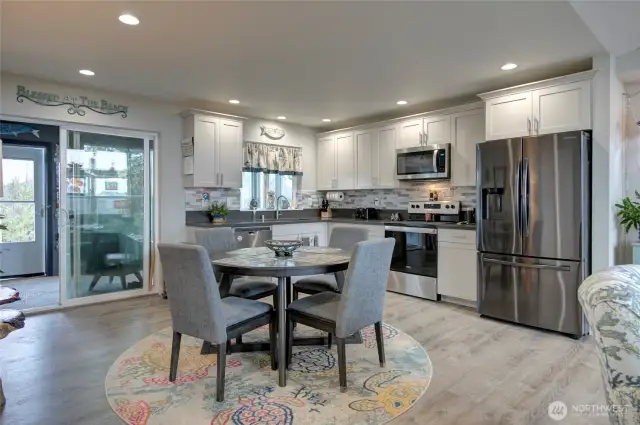 Living and dining space flow into the kitchen, and out to the covered sunroom.
