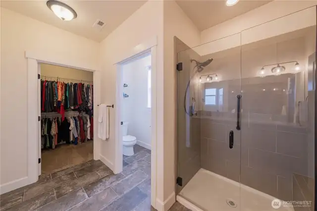 Primary spa like shower with frameless glass door and grab handle bar