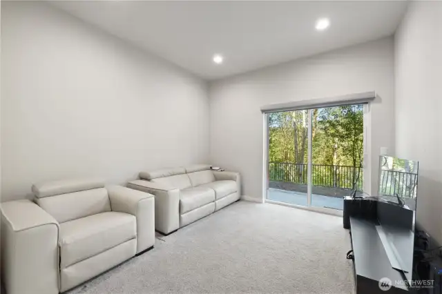 Downstairs family room offering ample space for relaxation and entertainment, with a sliding glass door that opens to a private patio, perfect for outdoor living