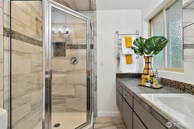 Updated ensuite bath with stylish finishes and cozy heated tile floors.