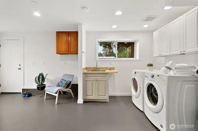 Oversized utility room with laundry, extra storage, and space for a hobby area or mudroom setup.