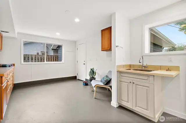 Oversized utility room with laundry, extra storage, and space for a hobby area or mudroom setup.