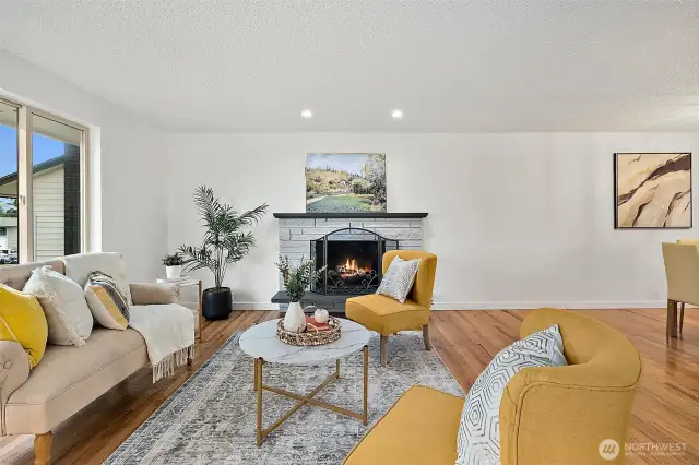 Freshly painted and full of natural light, the main living area with gas fireplace offers warmth, comfort, and seamless flow throughout the home.