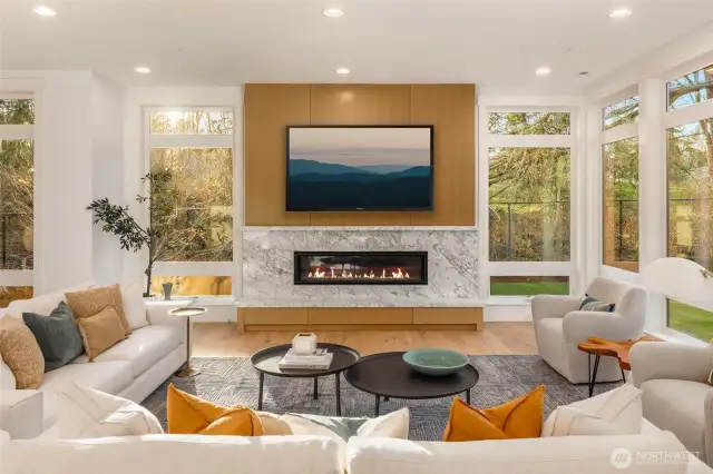 Stunning Great Room Fireplace framed by custom quartz slab and Custom built drawers and rift oak wall panels