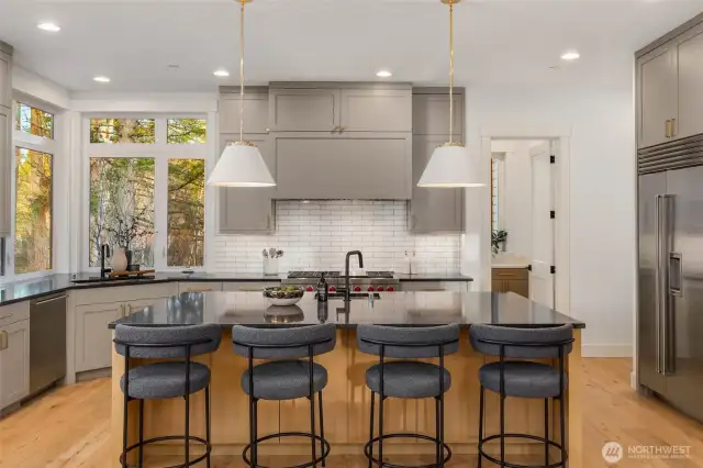 Bright and open chefs kitchen with commercial grade Wolf/Subzero appliance package, Large island with prep sink, and custom built cabinet details with matching flush commercial grade hood cover