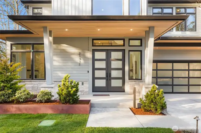Large covered entry patio with cedar ceiling detail and French Entry Doors