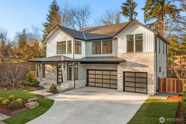 Large driveway leads to oversized 3 car garage with contemporary garage doors. Metal Roof detail adds to the charm of this custom home design