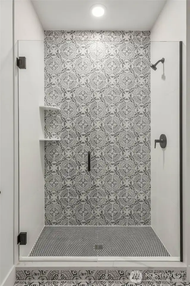 Stunning tile details in this designer mudset shower with frameless glass enclosure.