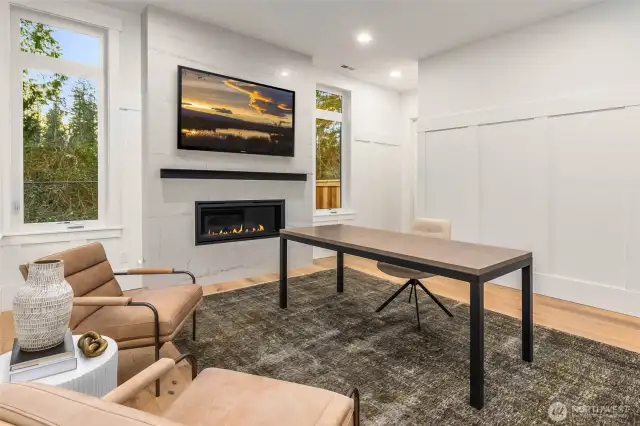 Dedicated Home Office off Entry highlighted by contemporary fireplace with custom floor to ceiling tile surround and custom formal wall panel details. Room also features large walk in closet and accesses main floor 3/4 bath and could be utilized as main floor guest suite