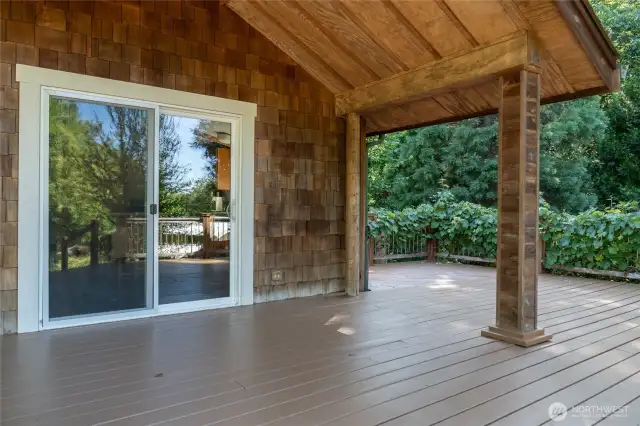 Partially covered deck with charming grape vines at your finger tipos!