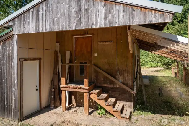 Storage room center. Man door to shop/storage area on left. Large carport on right.