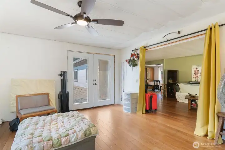 bonus room with ceiling fan and french doors to exterior of home.
