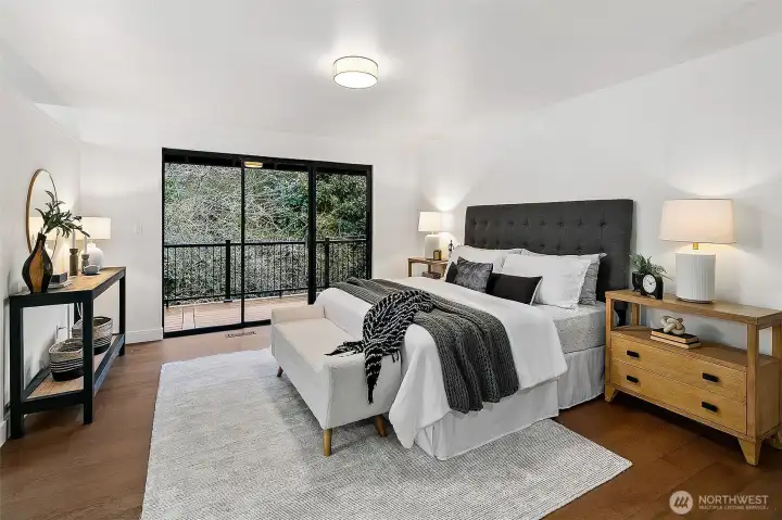 Primary bedroom on the main level also has deck access.