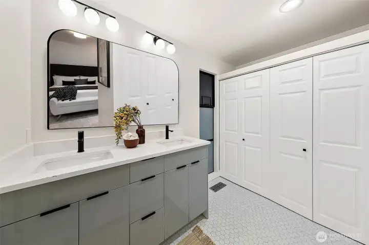 Primary en suite bathroom has walk-in dressing area and dual vanities.