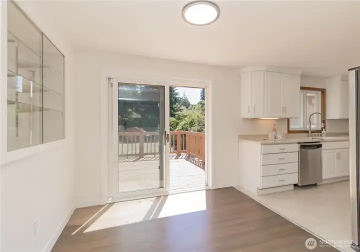 Dining area with built-in glass shelving and slider to deck