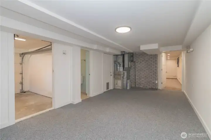Another view of flex space with wet bar/mini kitchen area through door on right