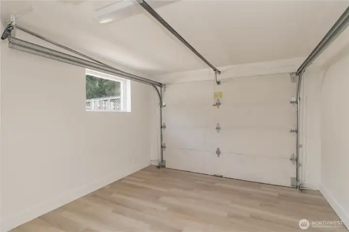 Finished garage/hobby space with LVP flooring and garage door to backyard