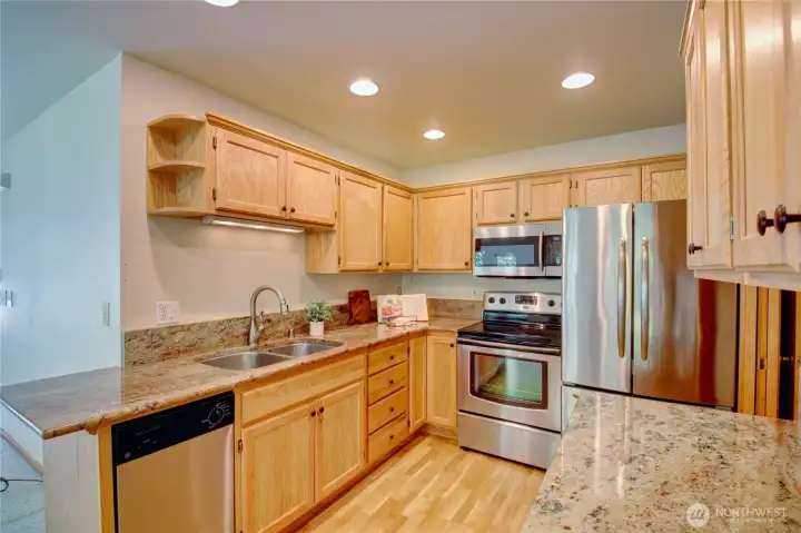Kitchen with granite counters, stainless appliances, loads of cabinets.