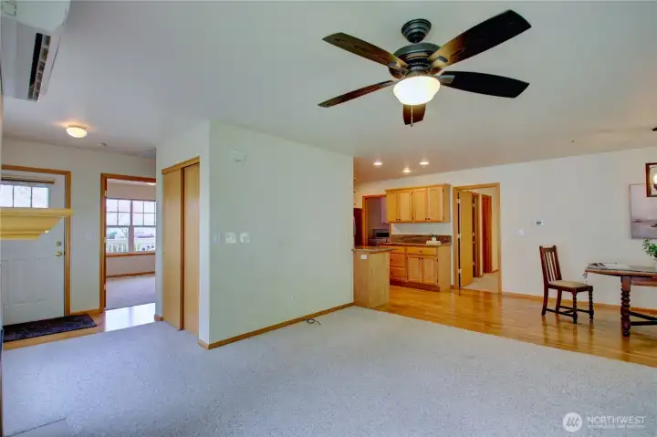 Looking from the living room to front door, 2nd bedroom, coat closet and into kitchen.