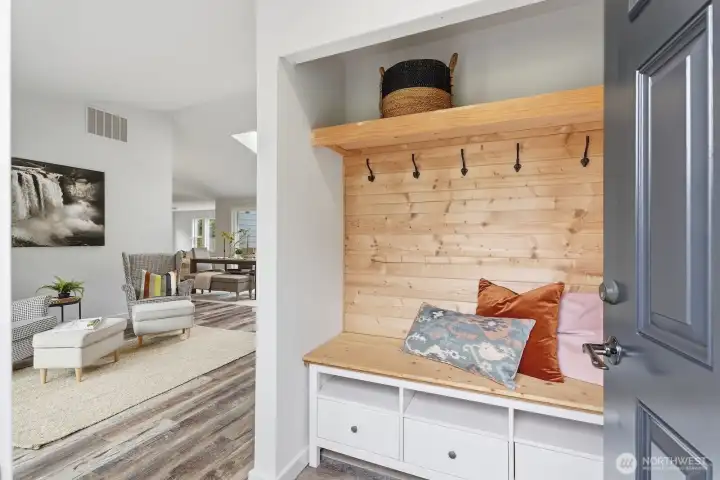 Thoughtfully designed built-in drop zone as you walk in, featuring custom cabinetry, a bench, and hooks for seamless everyday organization.