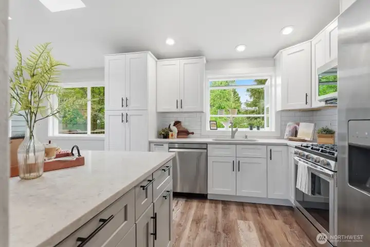 Stylish updated kitchen showcasing granite countertops, stainless steel appliances, and bright white cabinetry.