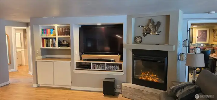 Custom shelving and electric fireplace in living room.