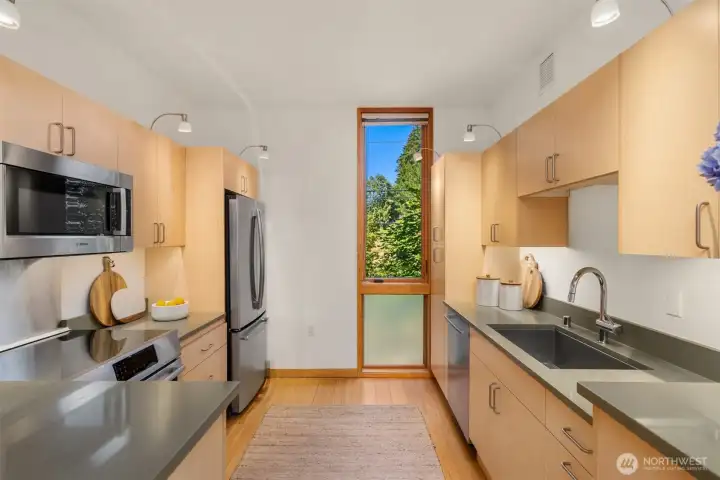 The kitchen’s efficient layout creates a great work triangle, with an extra-deep stainless sink, Bosch induction range, and counter-depth French door refrigerator. The window provides nice indirect light for your workspaces. The kitchen’s efficient layout creates a great work triangle, with an extra-deep stainless sink, Bosch induction range, and counter-depth French door refrigerator. The window provides nice indirect light for your workspaces.