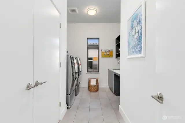 Huge laundry room with newer washer and dryer, and newer tankless water heater. Quartz countertops and stainless steel sink