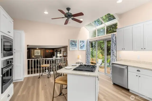 Kitchen has soaring ceilings and overlooks lower family room.