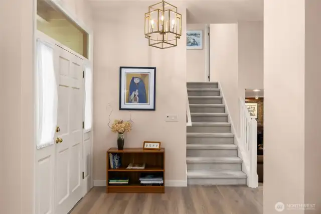 New LVP floors and stylish chandelier in entryway.