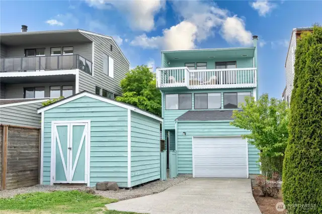 Back of home with storage shed and easy yard access