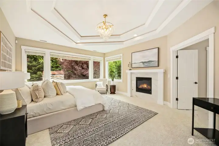 Luxurious primary suite w/ fireplace & spa-like ensuite featuring heated floors, freestanding tub, dual vanities & walk-in shower.