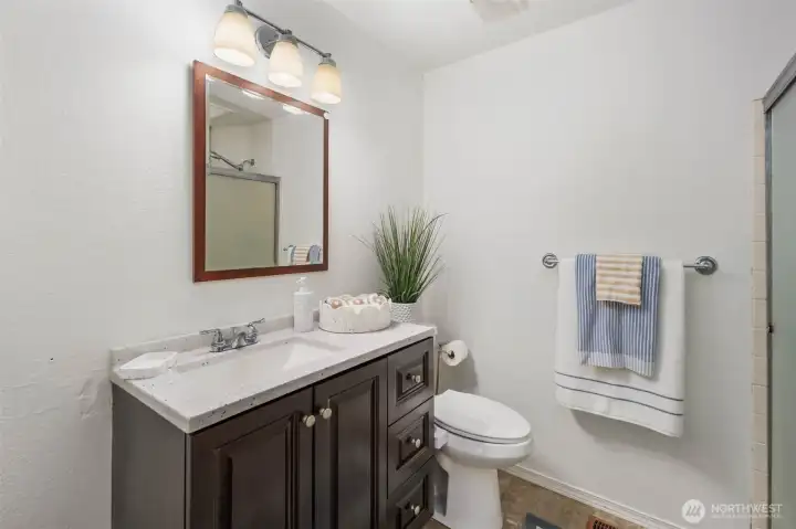 Primary bathroom with 1 sink and stand-up shower. 3/4 bathroom has a skylight that has been covered.