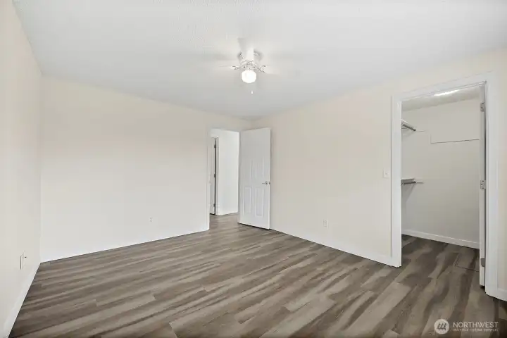 Second bedroom with walk-in closet and brand new flooring, plus a ceiling fan. Located on South wing of house.