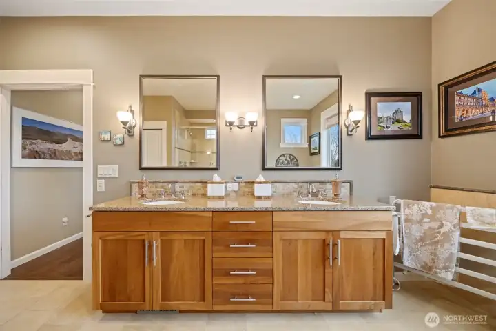 There is a large, dual sink vanity in the primary bathroom with a lot of counter space and storage.