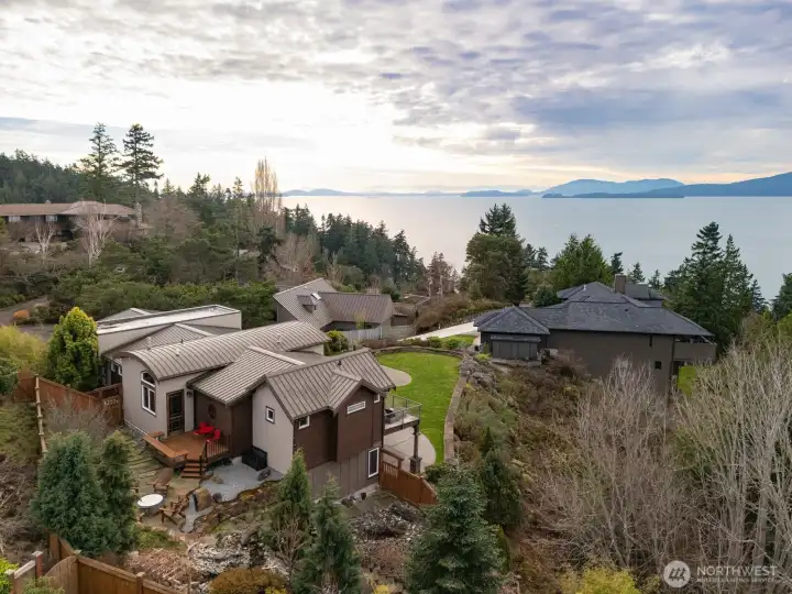 Looking down at the rear patio and water feature with the firepit that is all accessible from the office/den.