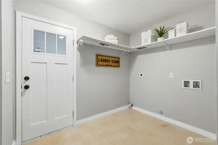 Huge utility room with door that leads to back patio and yard.