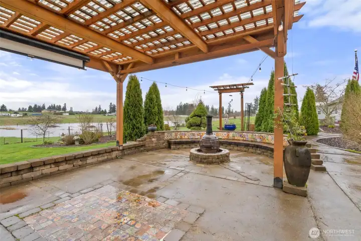 Covered gazebo with built in firepit and outdoor movie screen.